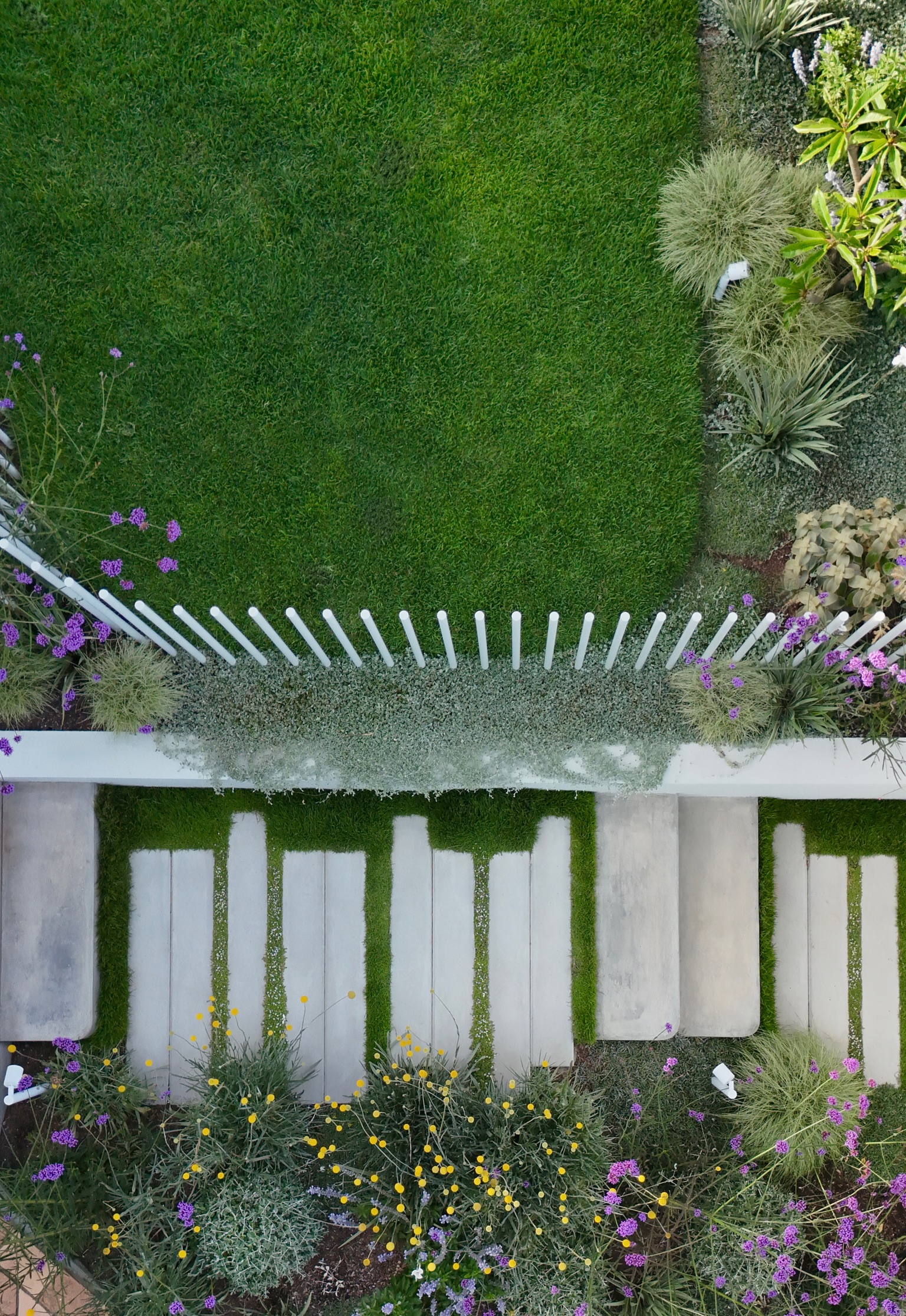 aerial view of a concrete garden path in a lush green setting