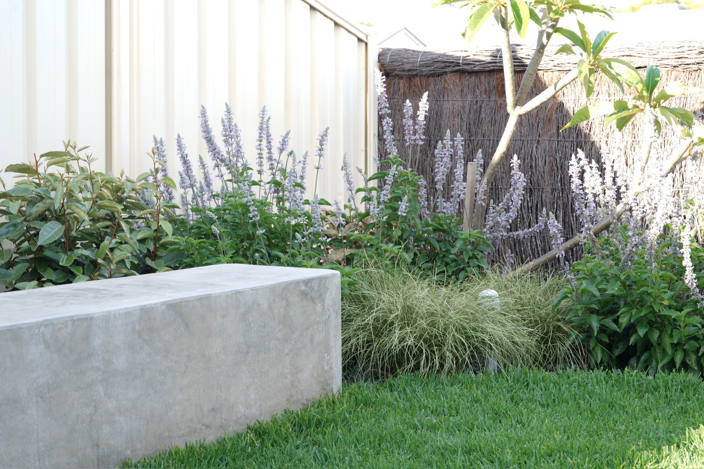 Boral concrete square bench in a lush green garden setting