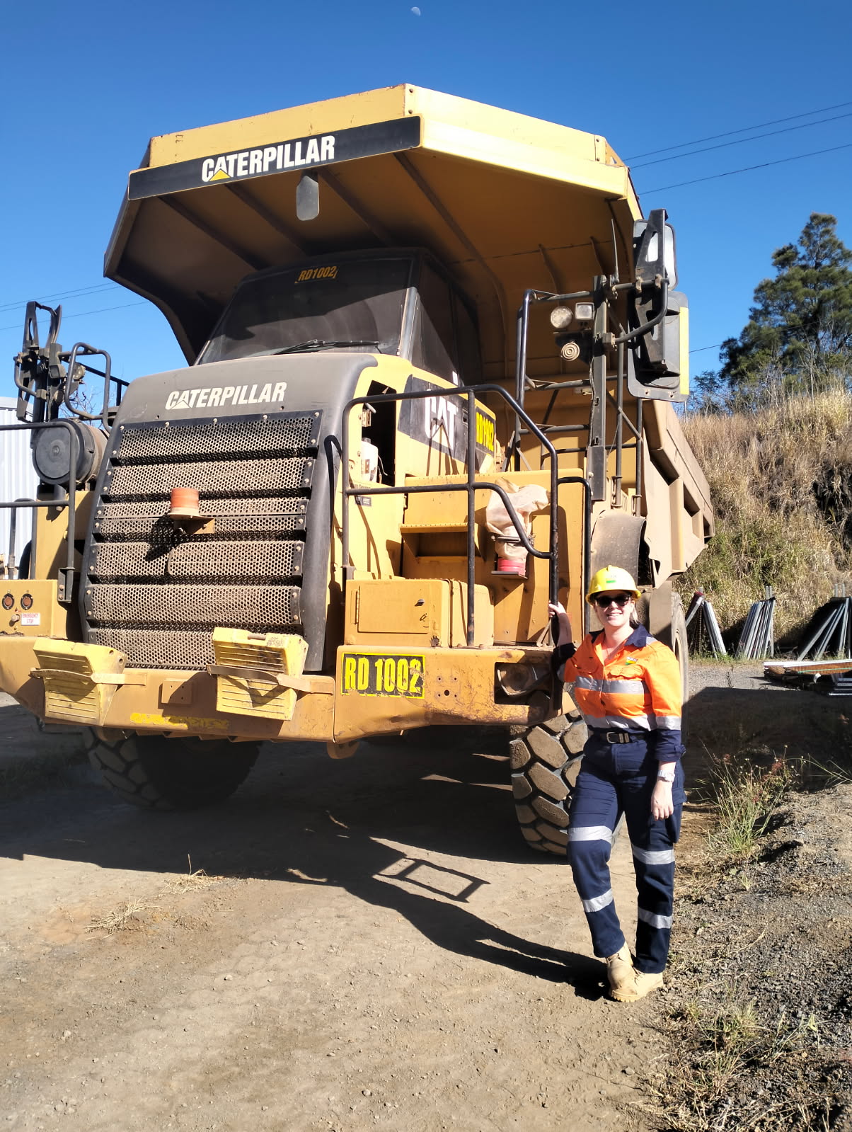 Hanna Moriconi standing in front of dump truck