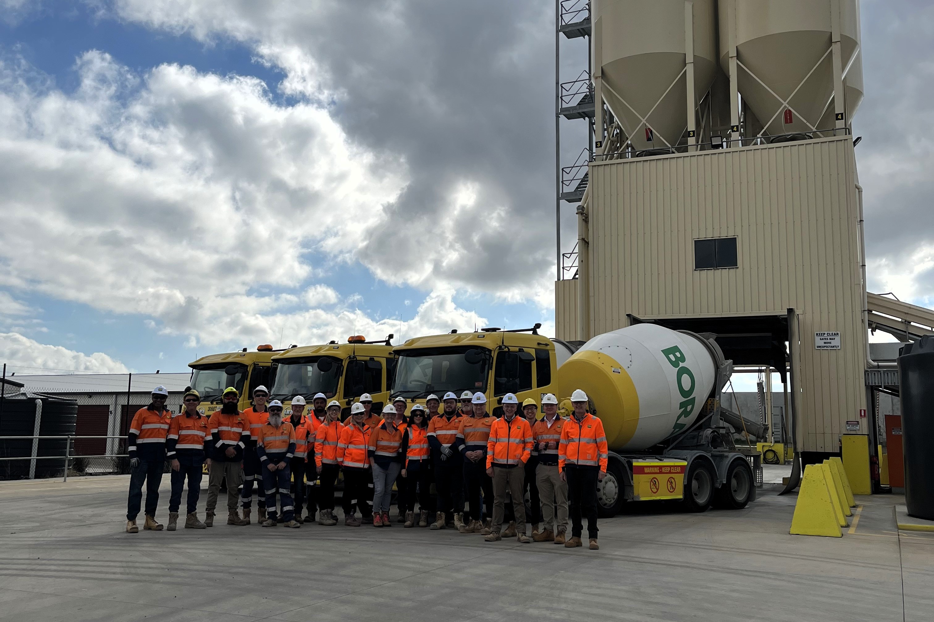 Boral Concrete Wallan team standing in front of silo and agitator trucks