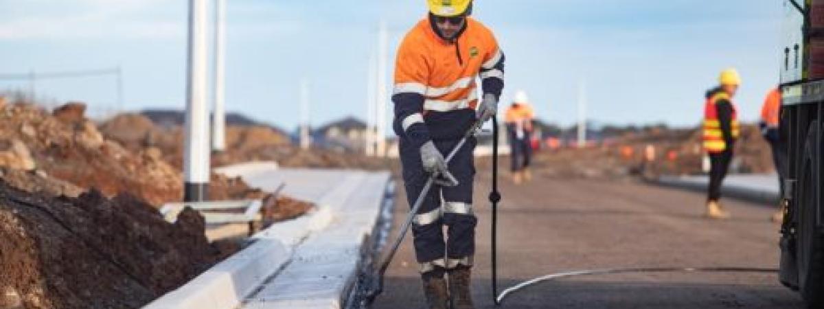 worker cleaning curb
