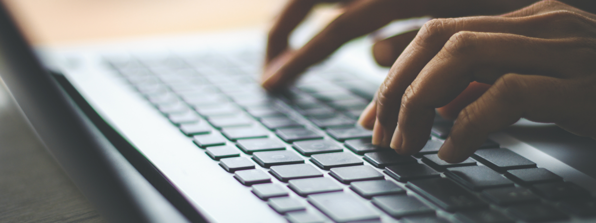 fingers typing on a laptop