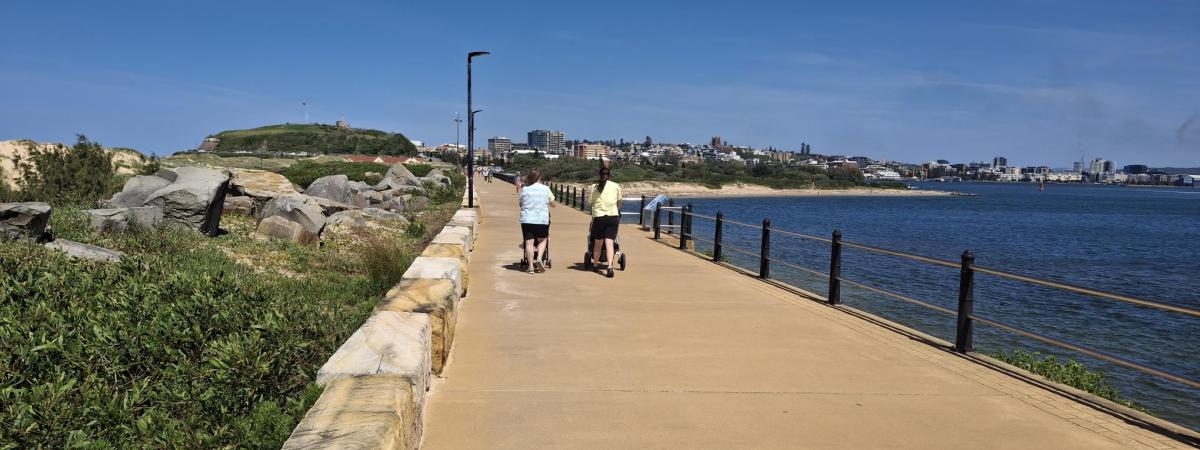 two people walking on pier with sandstone coloured concrete