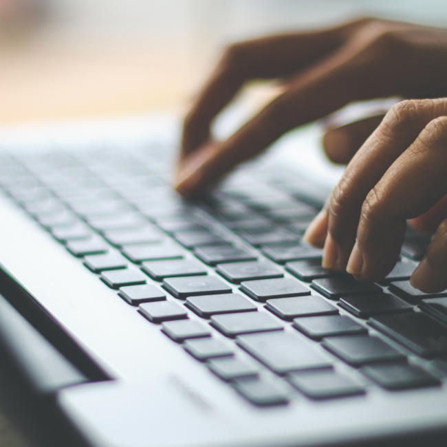 fingers typing on a laptop