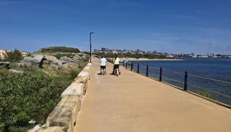 two people walking on pier with sandstone coloured concrete