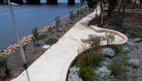 Coloured concrete pathway on Heirisson Island featuring Colori® Turmeric finish, connecting landscaped public spaces near Boorloo Bridge in Perth