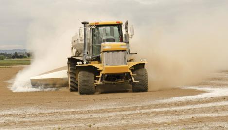 Tractor on farm spreading aglime into field