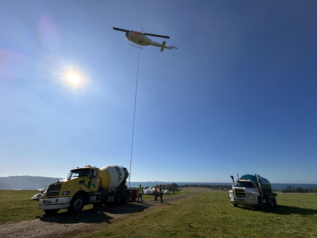 Helicopter transporting concrete in buckets