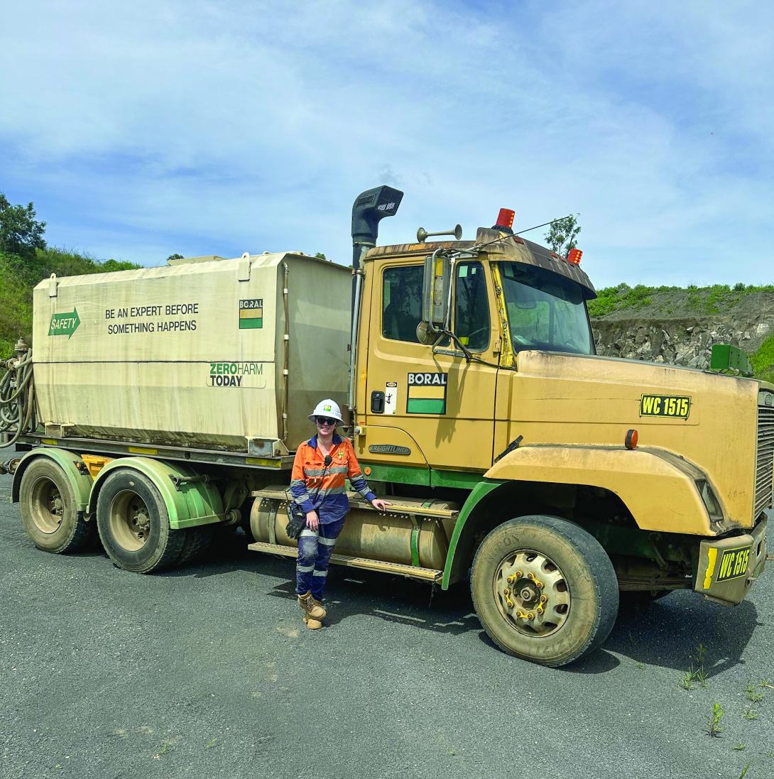 Hanna Moriconi standing in front of dump truck