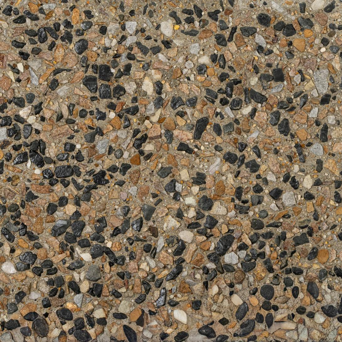 Close up of exposed concrete in shade Dragonfly, with warm earthy brown tones and black aggregates