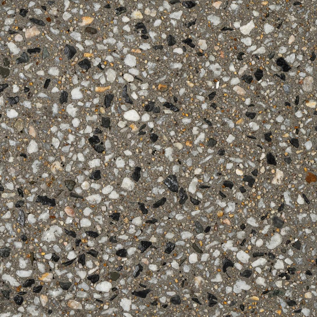 Close up of exposed aggregate concrete with dark grey base and black and white aggregates mixed through