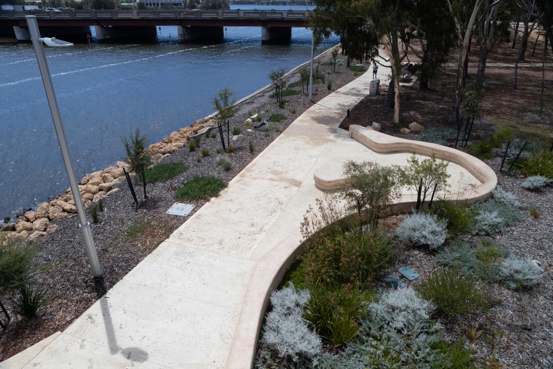 Coloured concrete pathway on Heirisson Island featuring Colori® Turmeric finish, connecting landscaped public spaces near Boorloo Bridge in Perth