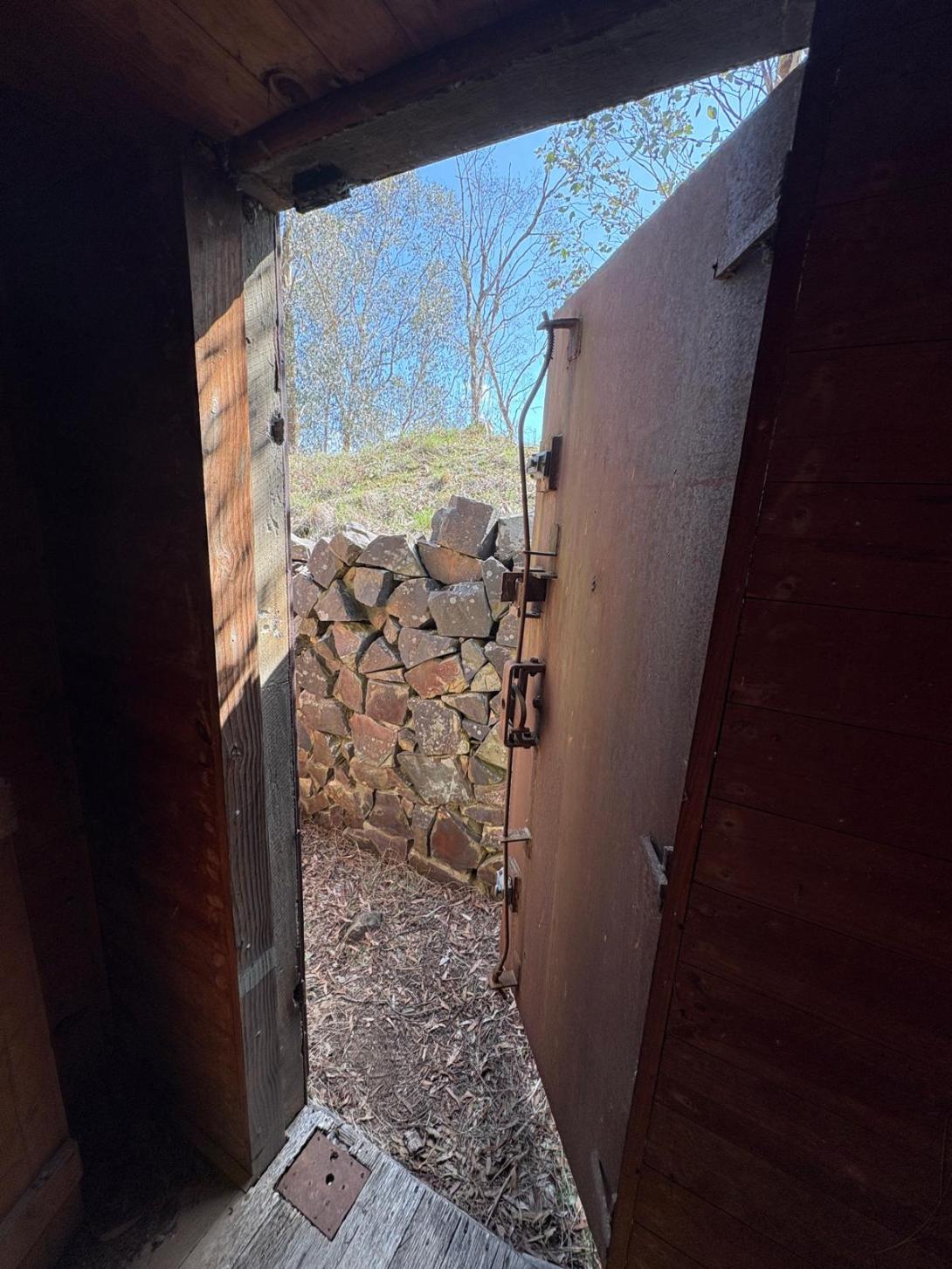 Historic explosives magazine at Coldstream Quarry surrounded by a dry-stone wall